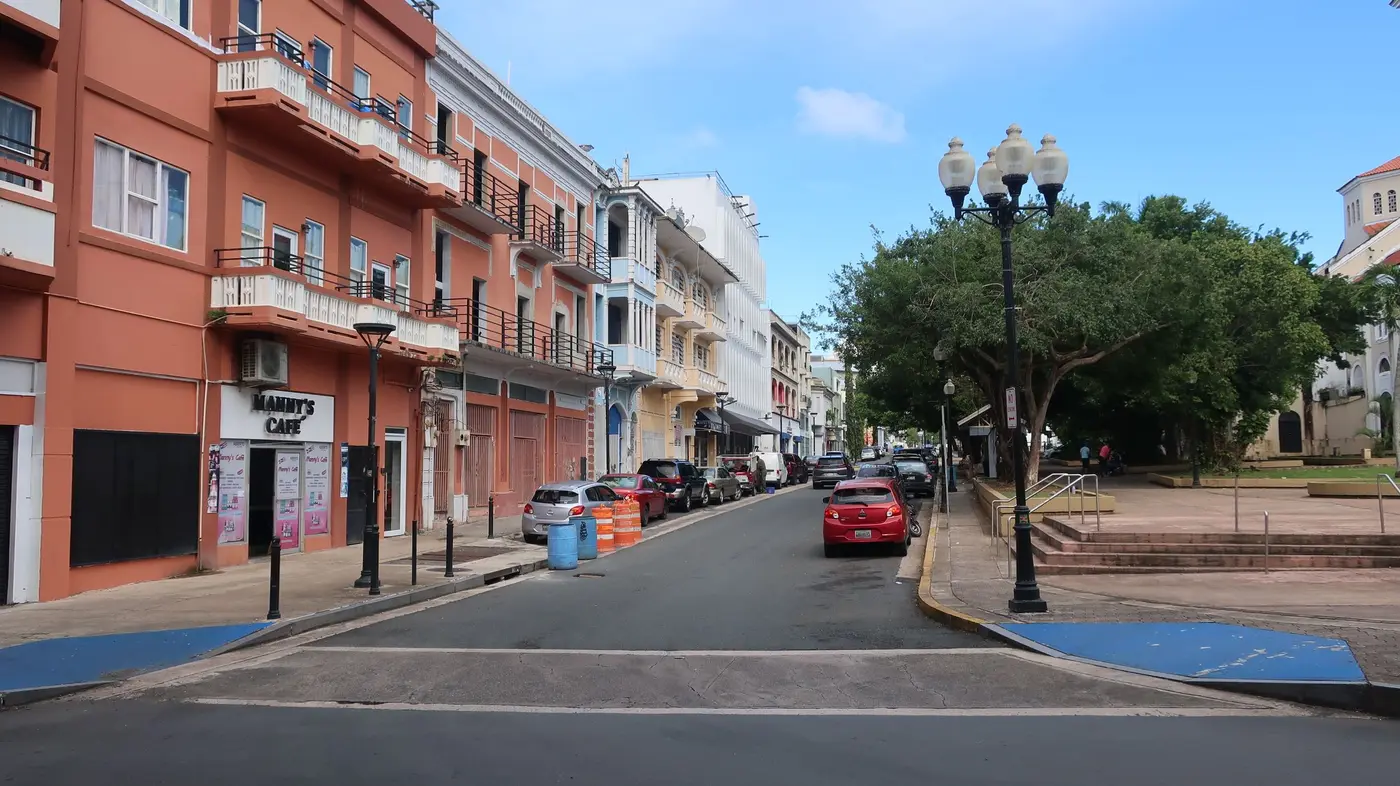 A pastel blue colonial building with wooden balconies on a street in Old San Juan, Puerto Rico.