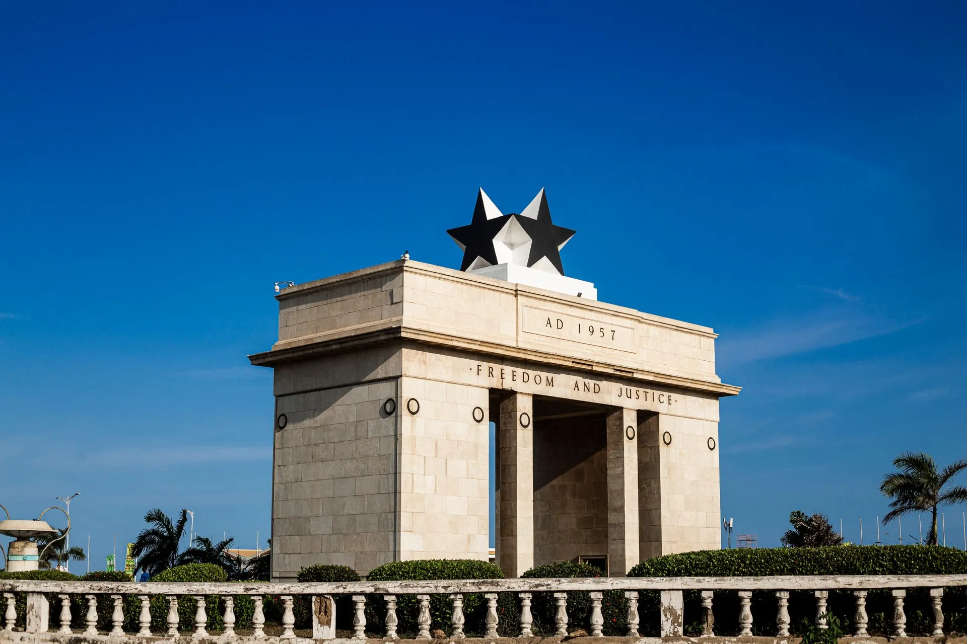 Independence Arch in Accra under a clear blue sky.