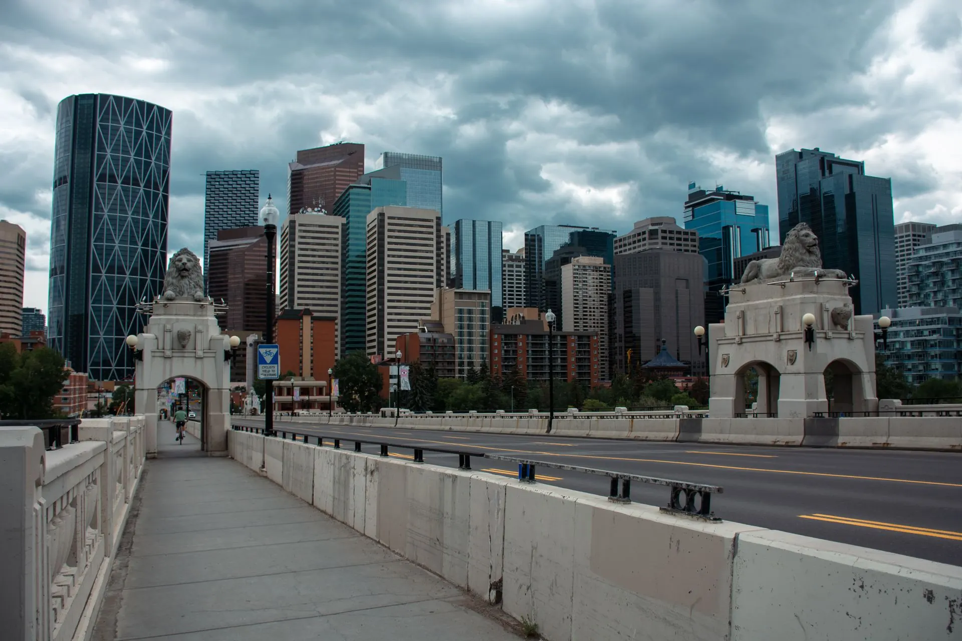 Downtown Calgary office towers under a cloudy sky, seen from the Centre Street Bridge.