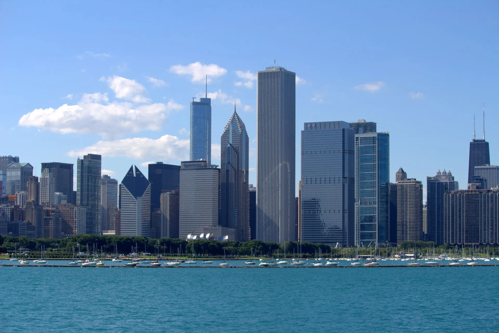 The Chicago skyline on a clear day from across Lake Michigan, with boats moored in the harbor.