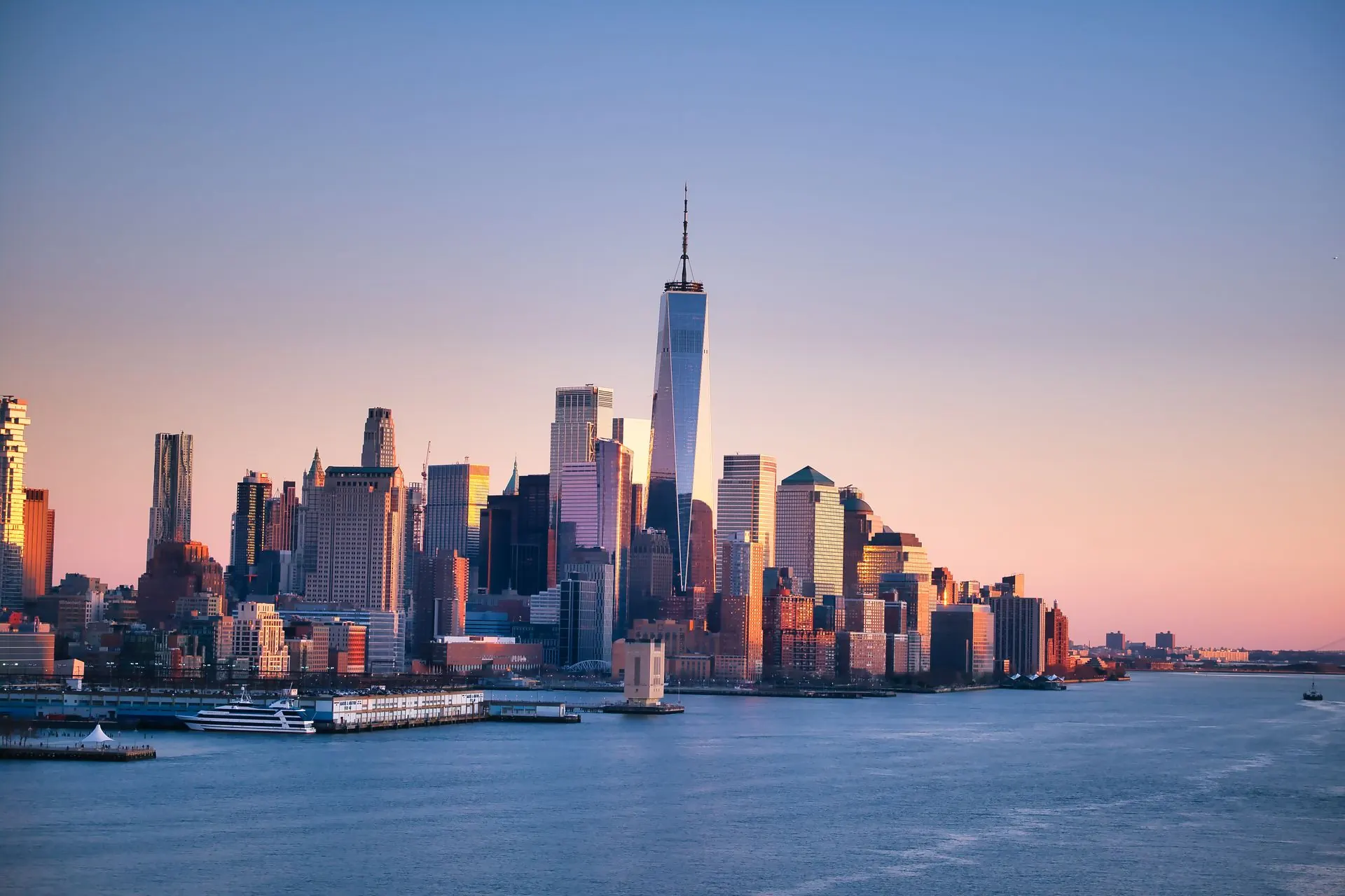 Lower Manhattan and One World Trade Center at sunset, seen across the Hudson River.