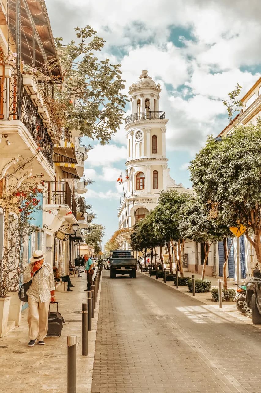 A street in the Zona Colonial of Santo Domingo, with a church tower and colonial facades.
